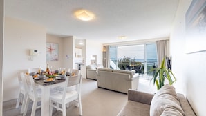 Een moderne woonkamer met een eethoek, een bank en een balkon met uitzicht.