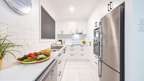 Enjoy cooking in this well-equipped kitchen with a stainless steel refrigerator, oven, and ample counter space.