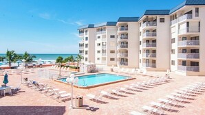 Un hôtel doté d'une piscine, offrant une vue sur la plage et comprenant plusieurs balcons.
