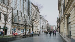 A city street lined with historic buildings, outdoor seating areas, and pedestrians. - Apartments IvanBeg (Belgrade)