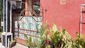 Un edificio rojo con una verja metálica y una ventana pequeña.