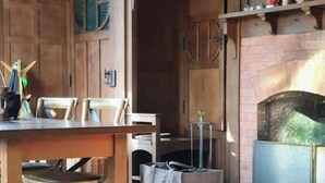 Ein rustikales Interieur mit einem Holzespeisetisch, Stühlen und einem Kamin.