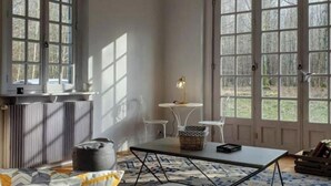 Ein Zimmer mit großem Fenster, einem Tisch und einem Stuhl.