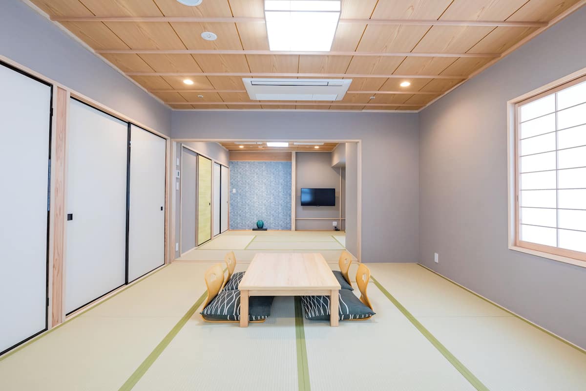 Une pièce de style japonais traditionnel, avec un sol recouvert de tatamis, une basse table en bois et des portes coulissantes.