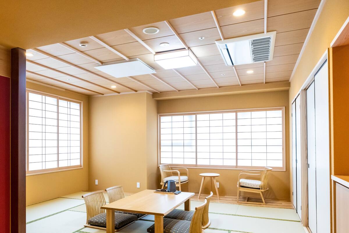 Une pièce de style japonais traditionnel, avec un sol recouvert de tatamis, une basse table en bois et des paravents en papier de riz (shoji).