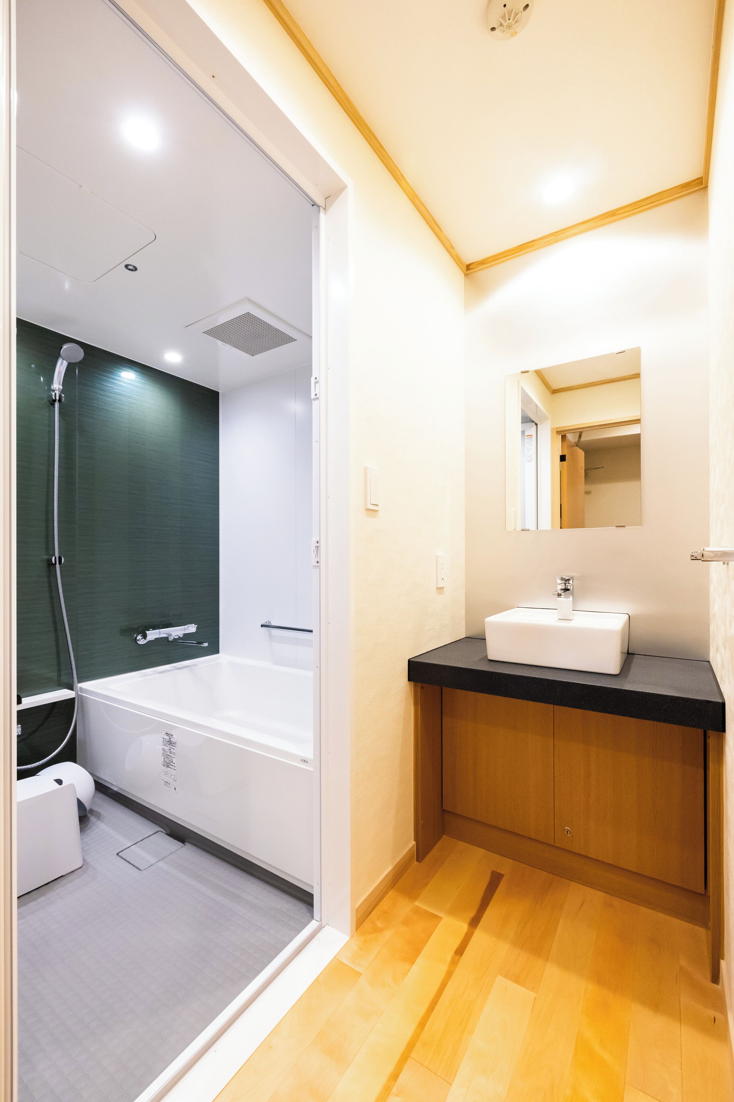 Un baño moderno con bañera, ducha, lavamanos y espejo.