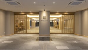 A hotel lobby with a central pillar, mirrored walls, and a tiled floor. - RYOKAN GINKAKU KYOTO (Kyoto)