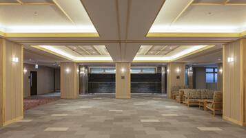 A spacious lobby with a checkered floor, a reception desk, and seating area.