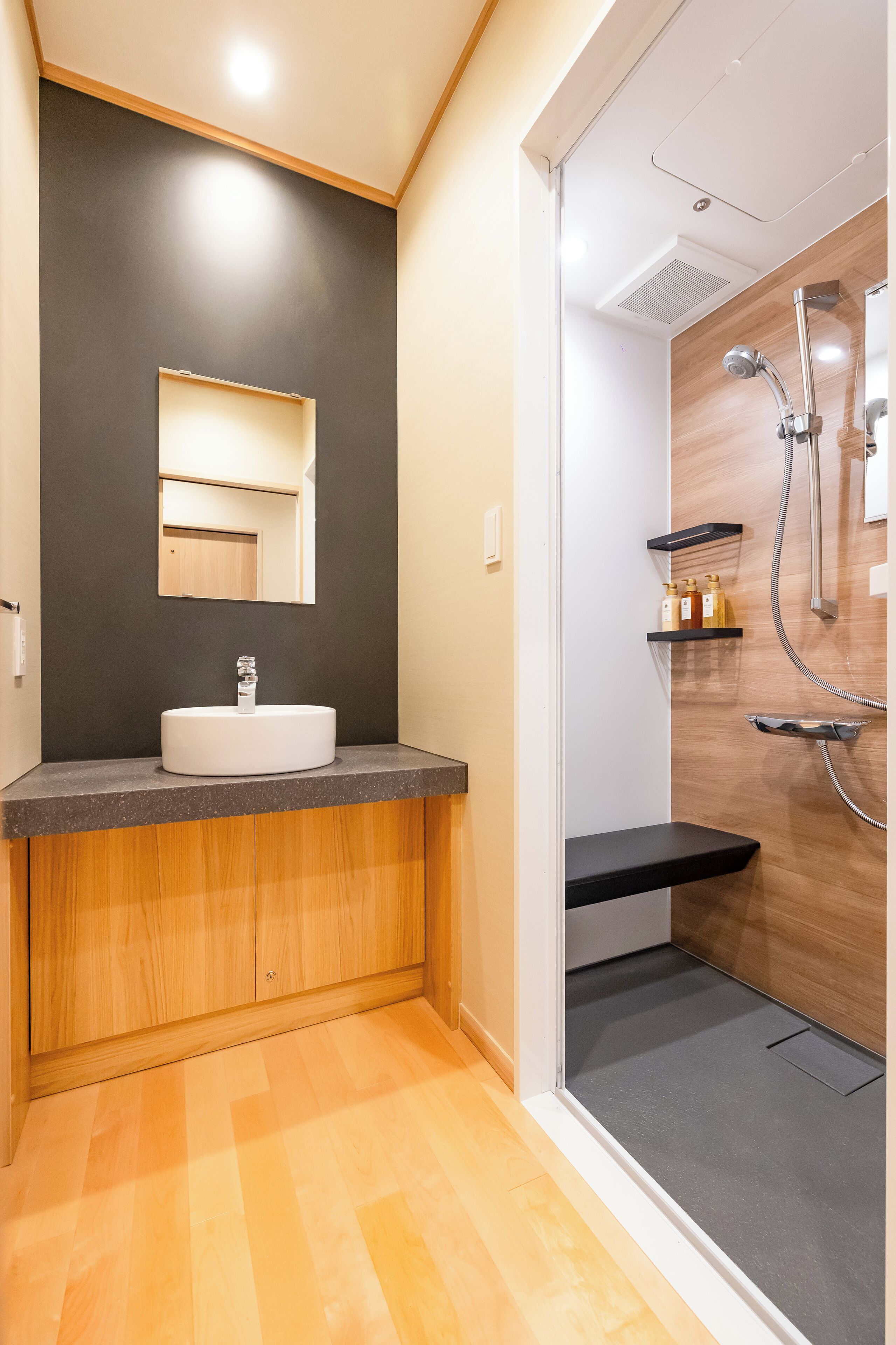 Ein modernes Badezimmer mit Waschtisch, Spiegel und Dusche.
