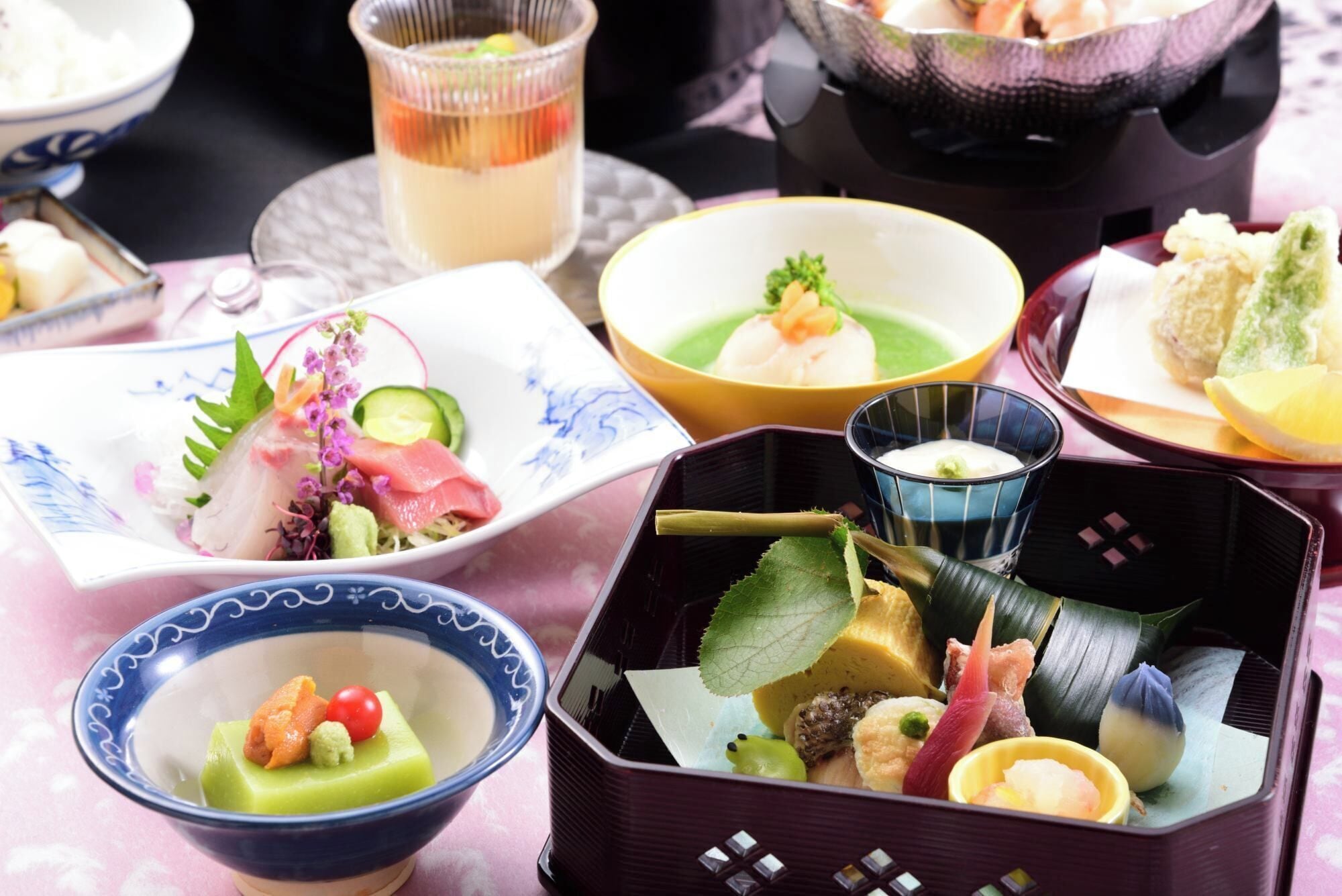A variety of dishes on a table, including sushi, sashimi, and other Japanese cuisine.