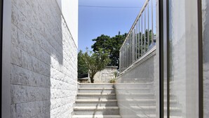A staircase leading to an upper floor, flanked by white walls and a glass door. - Spacious Basement Apartment Near Umag (Umag)