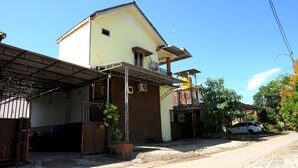 A two-story building with a covered garage and a small balcony.