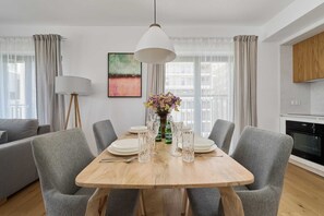 Enjoy meals in this stylish dining area with a table for four, grey chairs, and a pendant light.