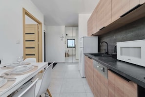 A modern kitchen with a microwave, dishwasher, and wooden cabinets.