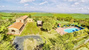 A large villa with a swimming pool, surrounded by lush green fields and a clear sky. - A magnificent Tuscan farmhouse, surrounded by greenery between the sea and the hills (Pomaia)