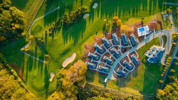 Vue aérienne d’un terrain de golf avec un club-house et un parking.