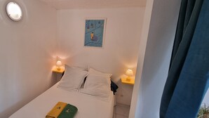 Un dormitorio con una cama, dos lámparas de noche, un reloj de pared y un cuadro enmarcado.