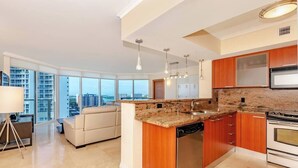 A modern kitchen with granite countertops, stainless steel appliances, and wooden cabinets.