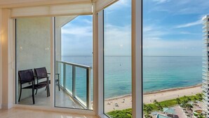 A balcony with a view of the ocean and a beach.