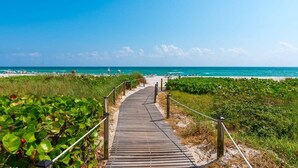 Un sendero de madera que conduce a una playa con cielos despejados.