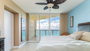 A bedroom with a bed, a ceiling fan, a large window, and a view of the sky. - High Floor - Unbelievable Ocean Views - 39th floor 3 Bedroom on the Beach! WOW (Sunny Isles Beach)
