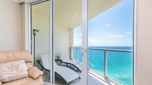 A balcony with a view of the ocean, a sofa with cushions, and two sun loungers. - High Floor - Unbelievable Ocean Views - 39th floor 3 Bedroom on the Beach! WOW (Sunny Isles Beach)