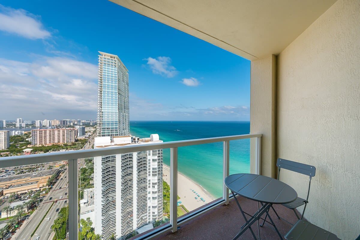 Un balcone con vista sulla spiaggia e un edificio alto.