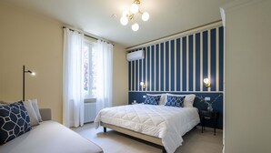 Een slaapkamer met een bed, nachtkastjes, een radiator, een raam met gordijnen en een wand met verticale strepen en wandlampen.