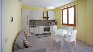 A compact living space with a kitchenette, a dining area, and a sofa. - Casa gli Ulivi: New cozy apartment, a few kilometers from Montepulciano.  (Montepulciano)