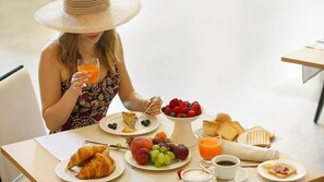 A breakfast setting with croissants, fruit, and juice. - VILLA ZOIA (Boltiere)