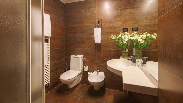 A modern bathroom with a toilet, bidet, and sink.
