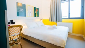 A hotel room with a bed, a chair, and artwork on the wall. - The People Caen (Caen)