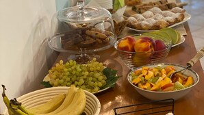 Een ontbijtbuffet met verschillende soorten fruit, gebak en brood.