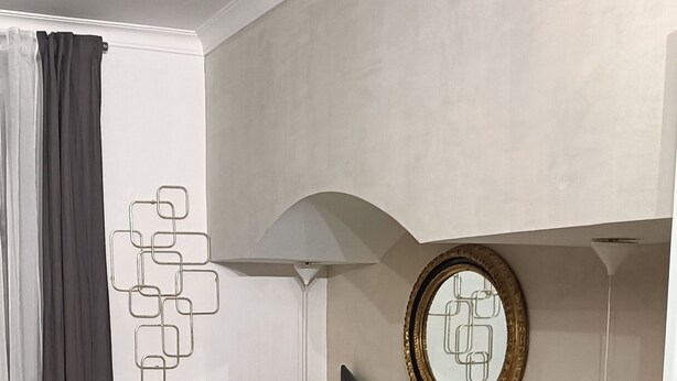 A bedroom with a bed, pillows, a chair, a lamp, and a mirror. - Contemporary Art apartments by Spanish steps, Cozy space in the center of Rome. (Roma)