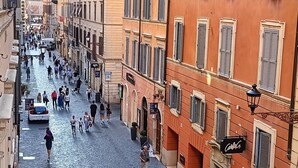 A cobblestone street lined with historic buildings, a café, and a bicycle. - Contemporary Art apartments by Spanish steps, Cozy space in the center of Rome. (Roma)