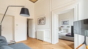 A modern living room with a grey sofa, a black floor lamp, and a TV on a stand. - Charm and Style by The Spanish Steps (Roma)