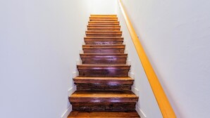 A wooden staircase with white walls and a yellow handrail. - Casa de Santana (Lisbon)