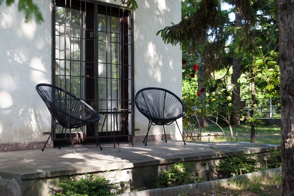 Sit and unwind in a serene outdoor space surrounded by lush greenery and a unique seating area.