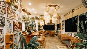A cozy interior with wicker furniture, a bar area, and various wall-mounted decorations. - Mambo Hill Resort (Penida Island)