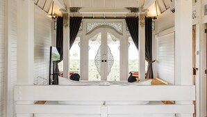 A white bed with a view of a balcony, white walls, and a decorative ceiling. - Mambo Hill Resort (Penida Island)