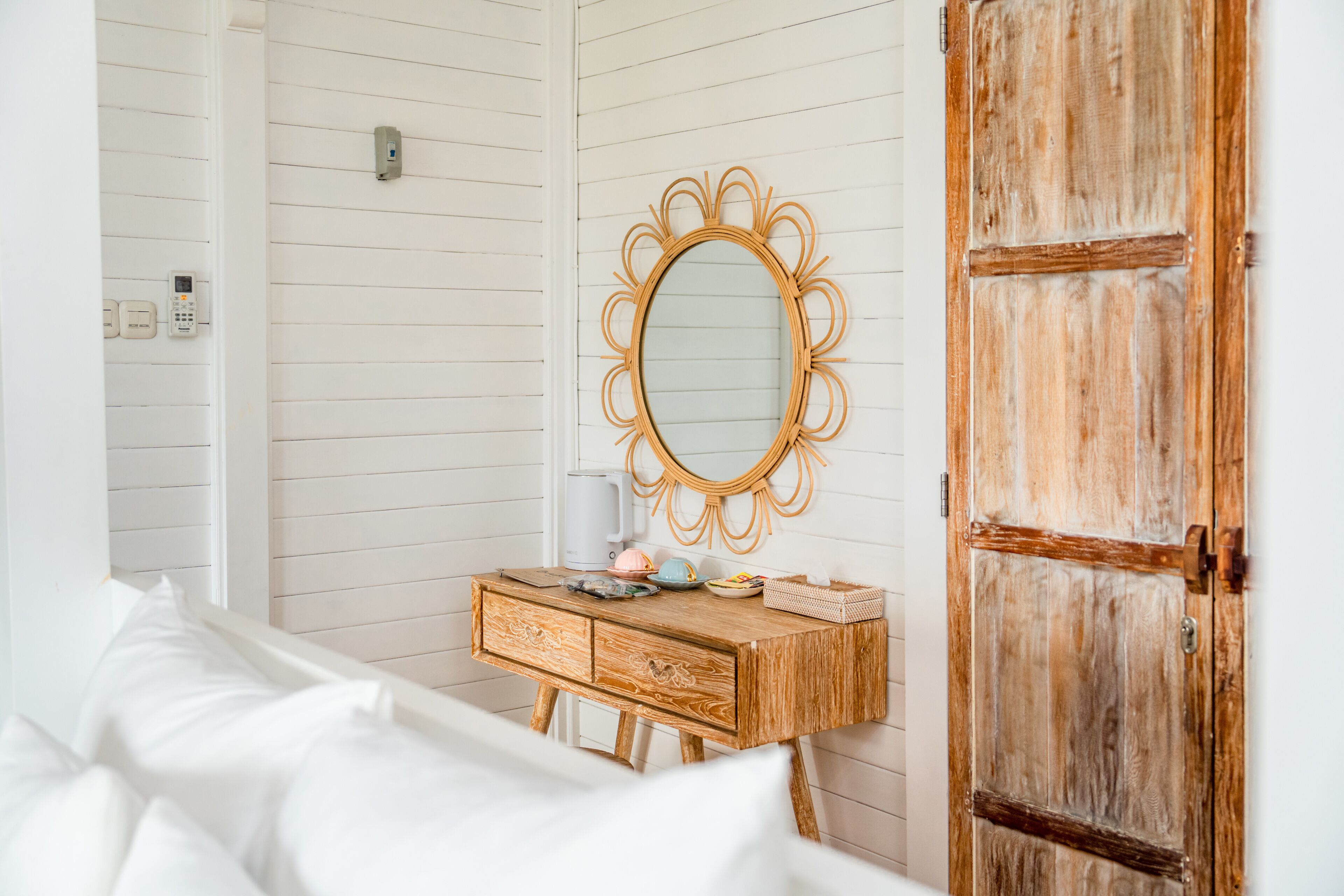 Un dormitorio con un aparador de madera, un espejo y una puerta rústica.