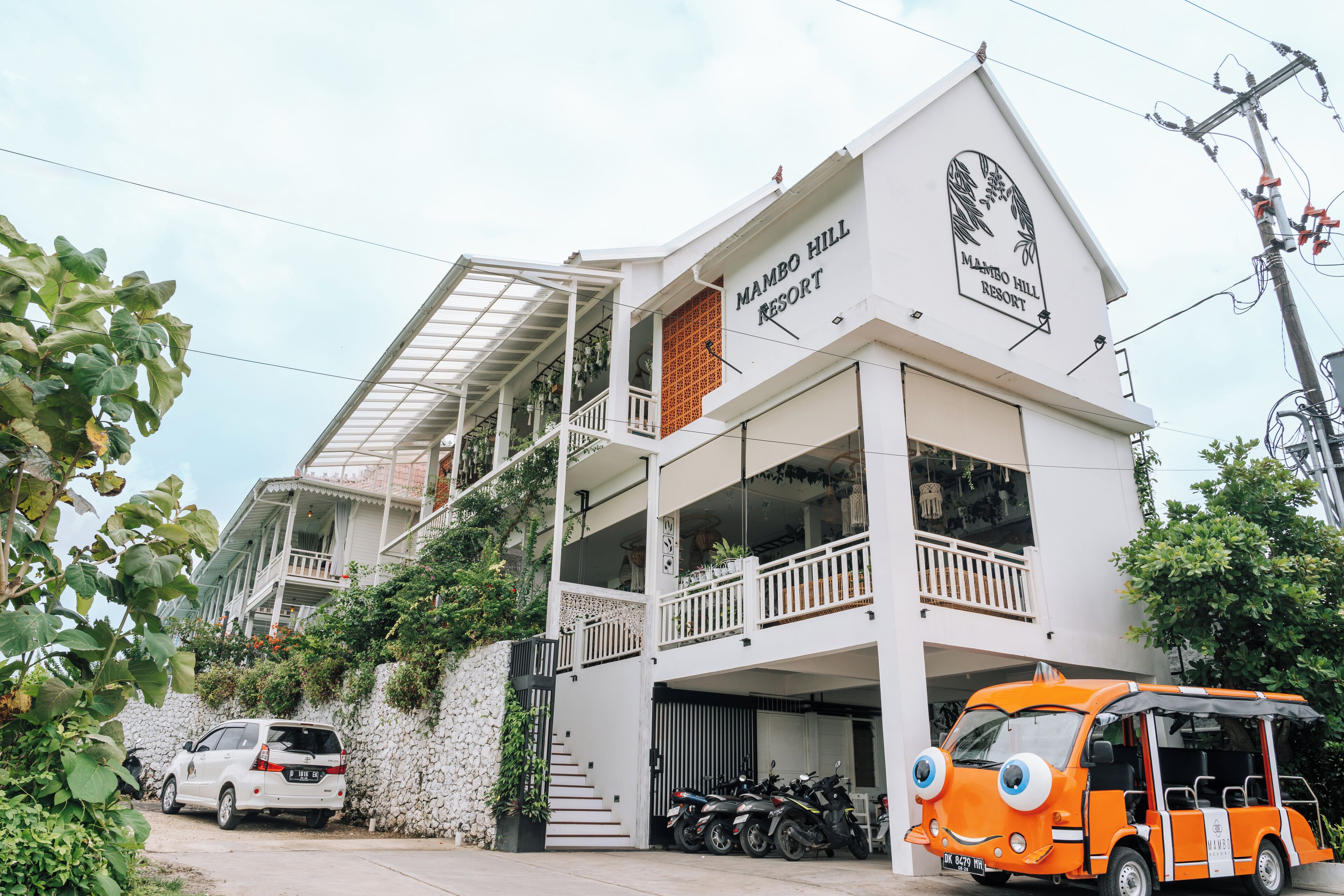 Un edificio de dos pisos con balcones y un letrero que dice "Mambo Hill Resort".