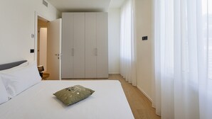 Une chambre d’hôtel avec un lit, une armoire et une salle de bain.
