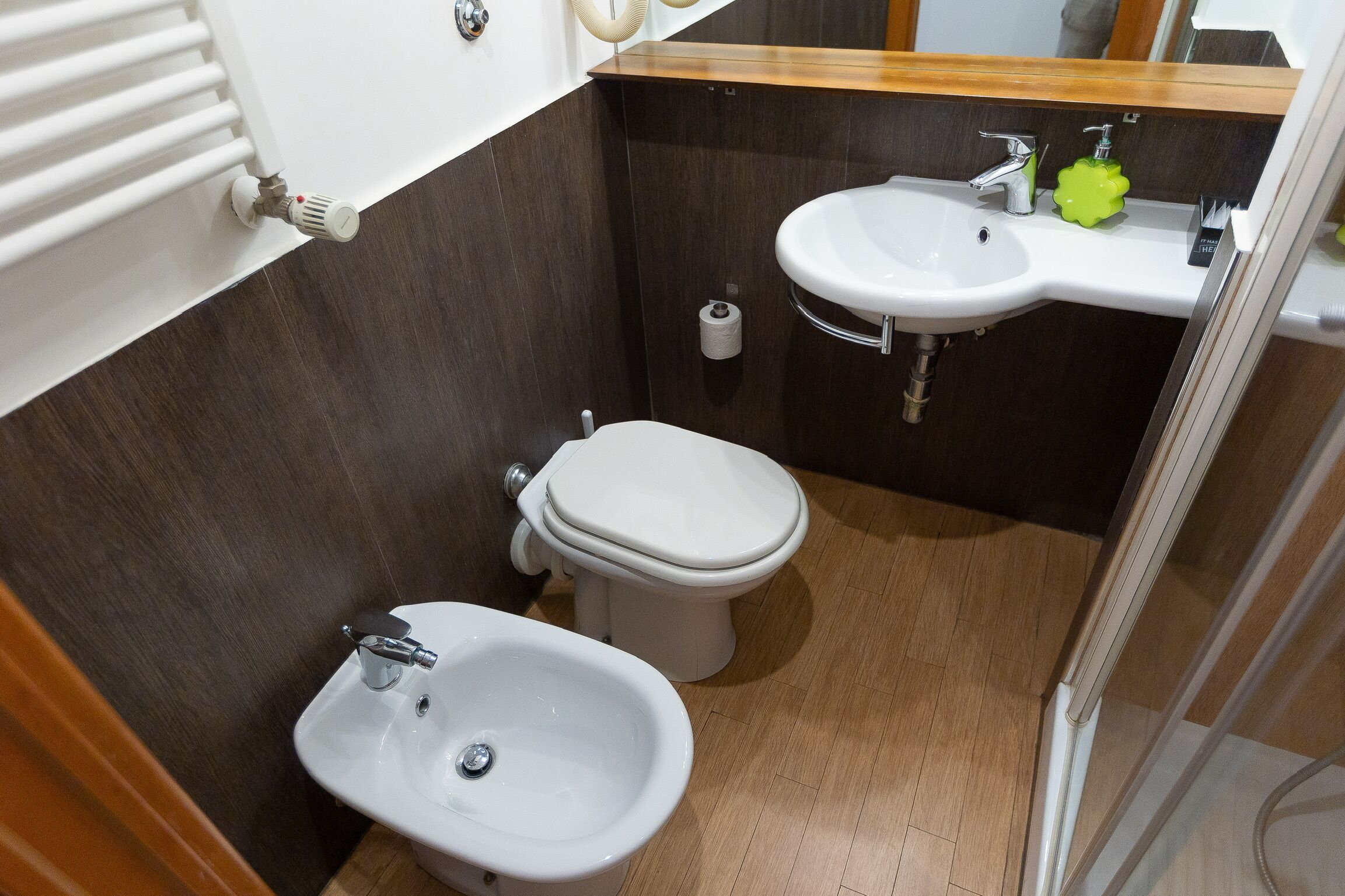 Ein kleines Badezimmer mit Toilette, Bidet und Waschbecken.
