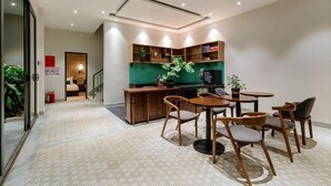 A modern kitchen with wooden cabinets, a dining area with a round table and chairs, and a ceiling fan. - Lacasa Old Town Villa (Da Nang)