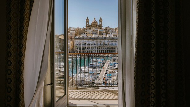 A balcony with a view of a marina and a historic building with domes. - IBB Hotel Palazzo Bettina Malta (Birgu)
