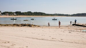 A beach with boats, people, and a sandy shore.