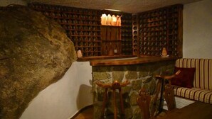 Un coin douillet avec une cheminée en pierre, des étagères en bois et un canapé à rayures.