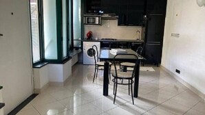 A modern kitchen with a dining area, including a table and chairs, a microwave, and a refrigerator.