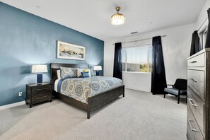 A bedroom with a bed, bedside tables, a dresser, a window with curtains, and a ceiling light fixture. - Sparkling New 3 Bed 3 Bath Private Pool Home With Incredible Views #260292 (La Quinta)